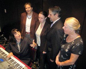 People singing around piano