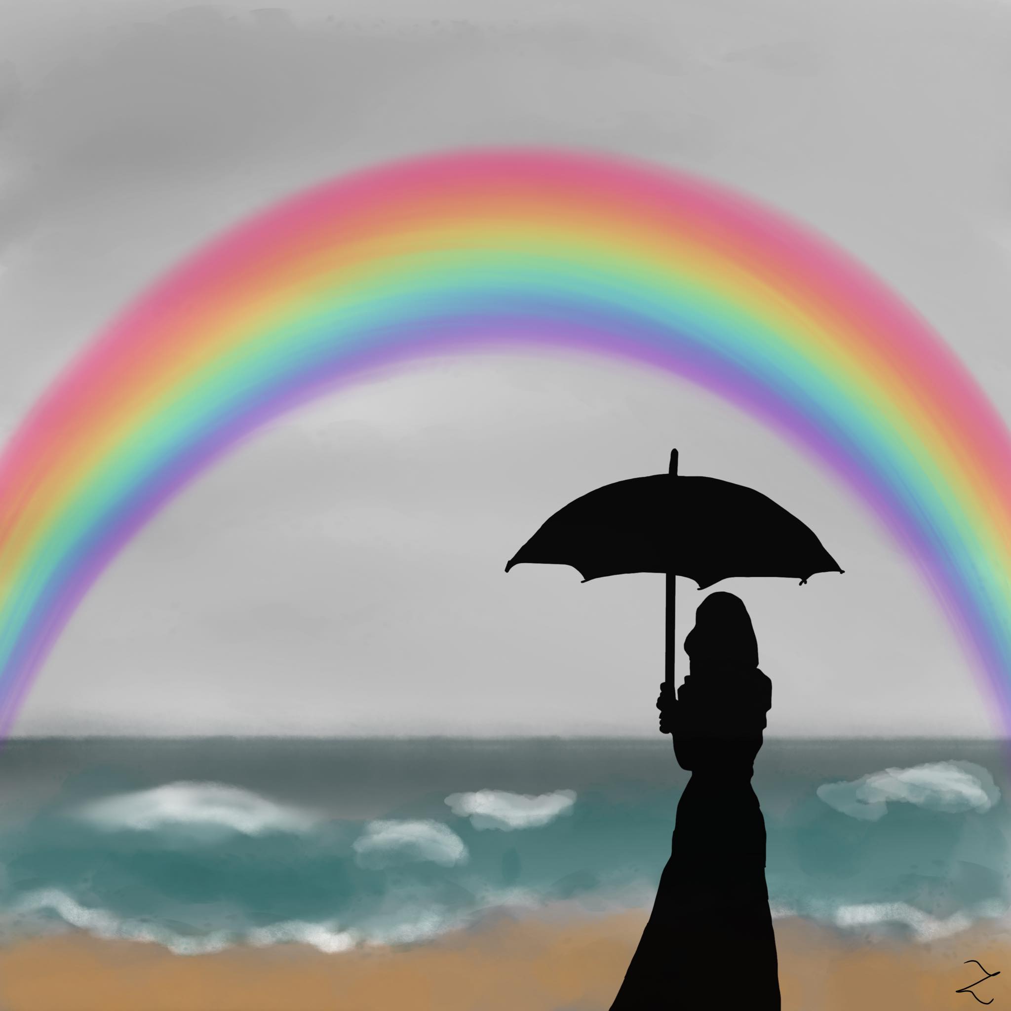 woman at the ocean with a rainbow